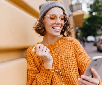 Smiling girl looking at her mobile phone screen